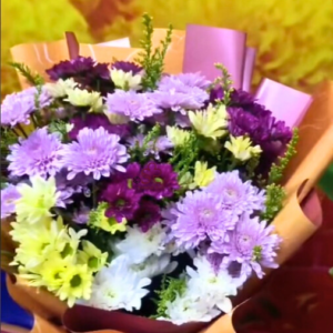 Lush Mother's Day bouquet featuring layers of fresh purple, lavender, and white chrysanthemums wrapped in natural brown kraft paper.
